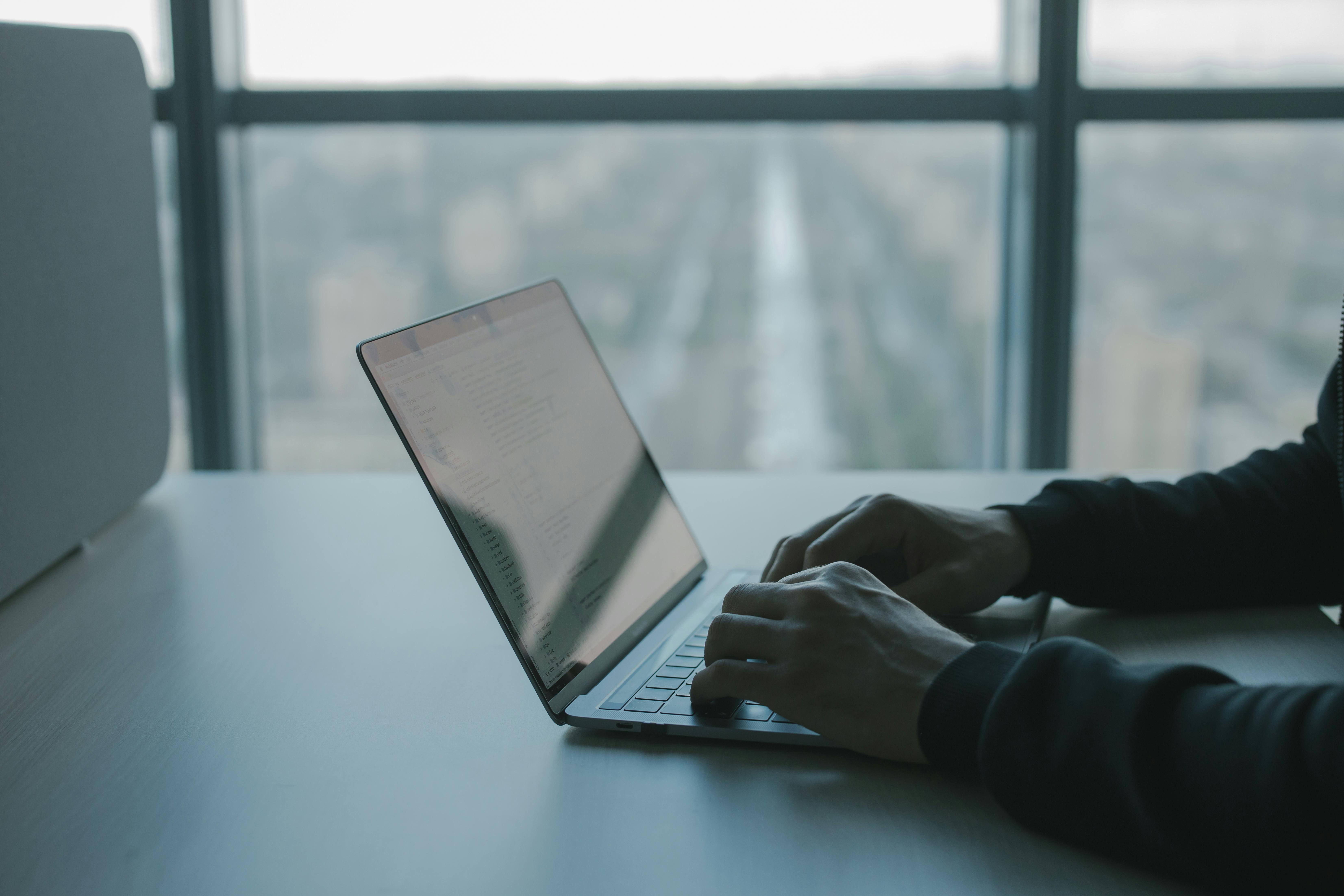 Un homme écrivant sur un clavier d'ordinateur portable